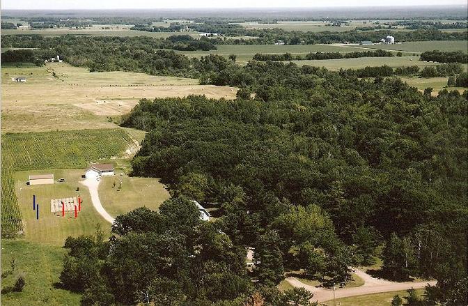 This is an aerial view of my home site. The house you see in the pic is my neighbors. My house is in the trees.
<br />
<br />The martin housing is in the lower left of the picture. The red poles show where the housing is currently located. The blue poles represent